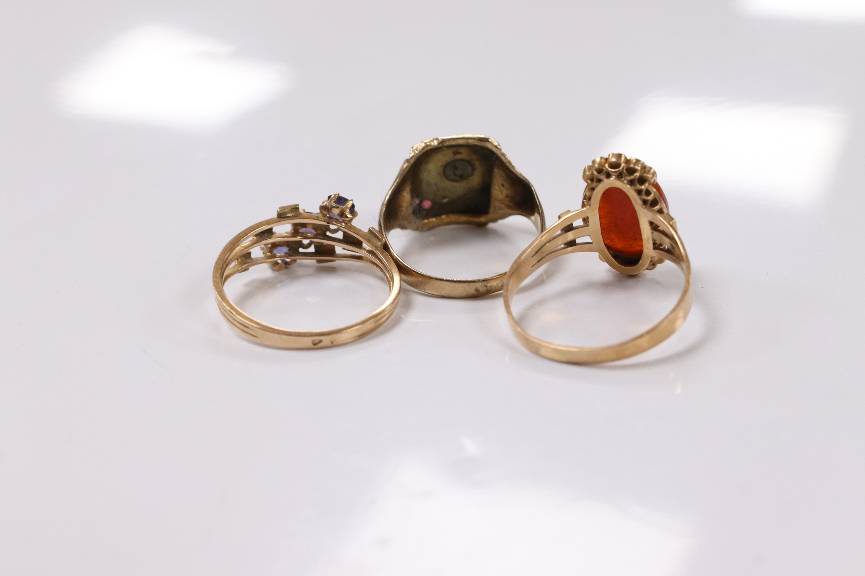 A 10k and gem set initial ring, a continental yellow metal and gem set ring and an early 20th century yellow metal, hardstone cameo and seed pearl set ring, size P, gross weight 8.2 grams. Condition - poor to fair